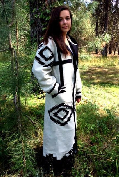Long wool coat, white with black geometric pattern accents.